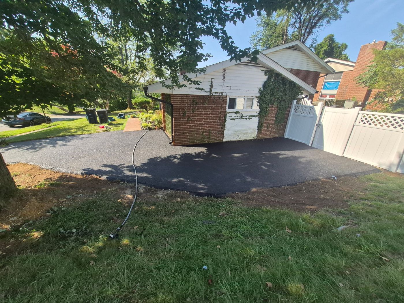 Finished new asphalt driveway beside the house